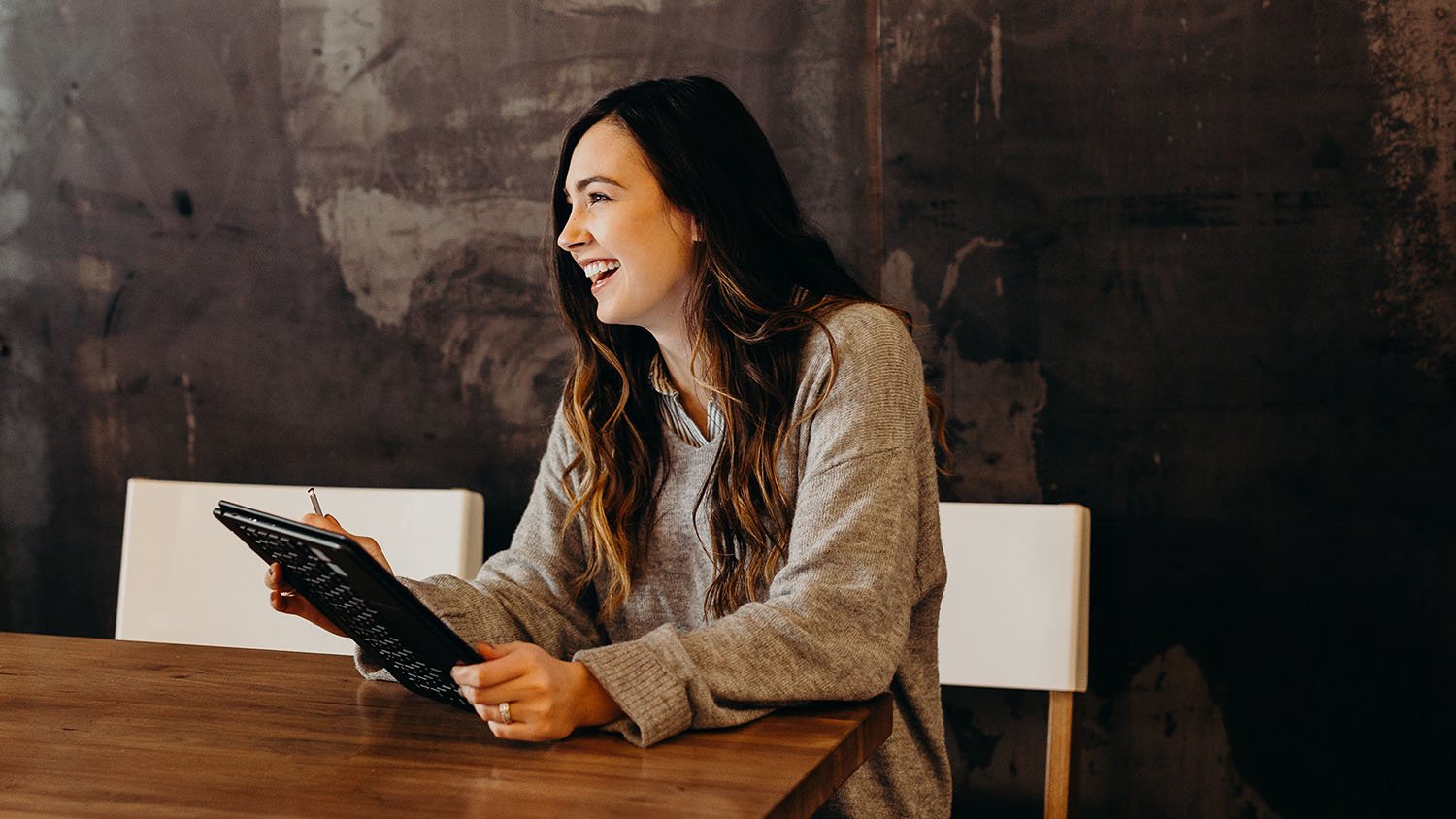 Woman sitting at desk with a tablet