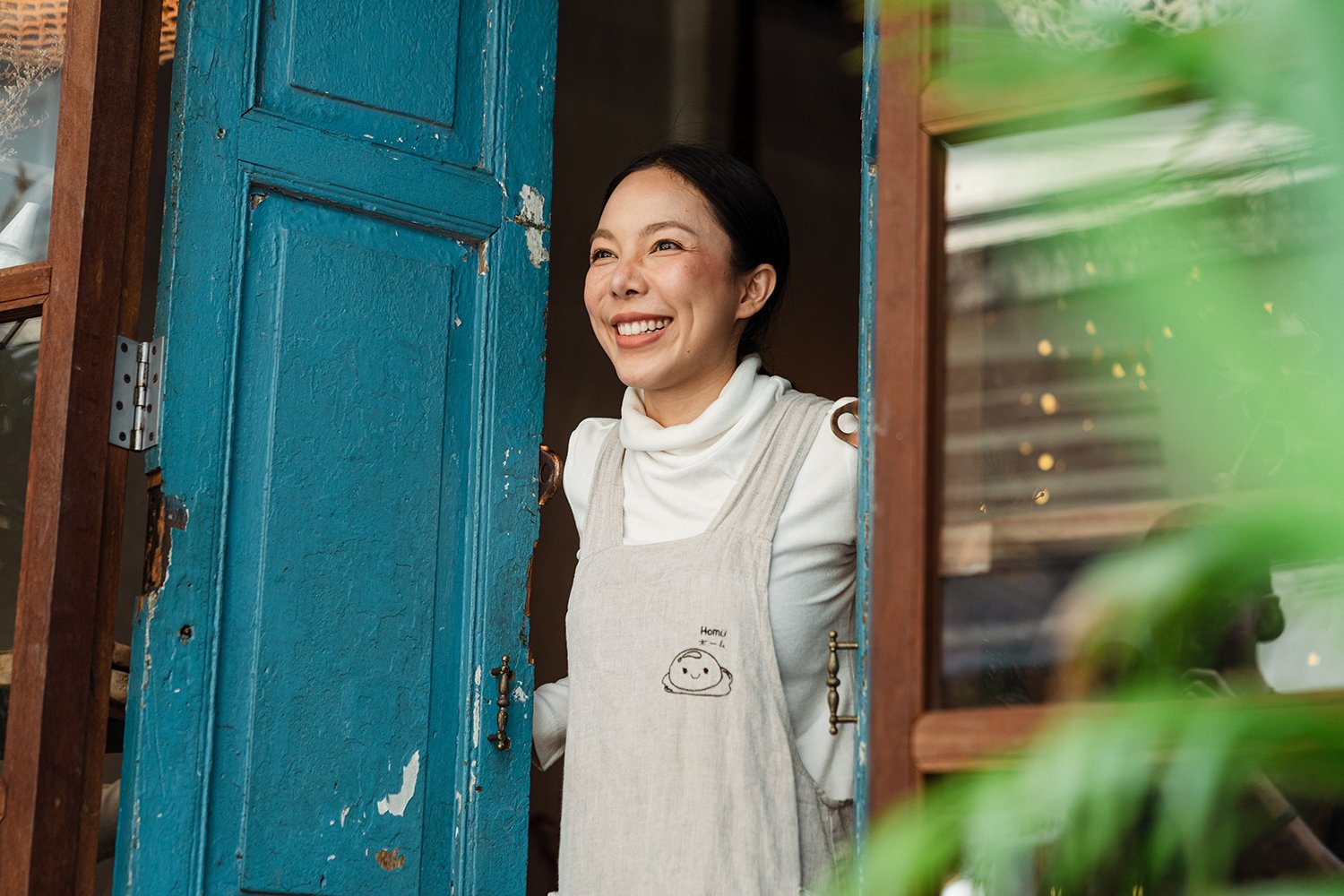 Cafe owner looking out the door smiling