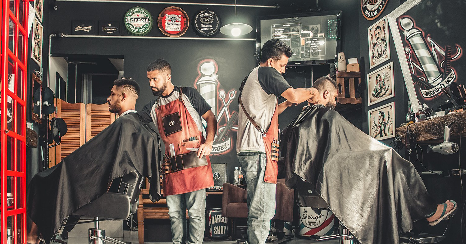 two barbers cutting hair